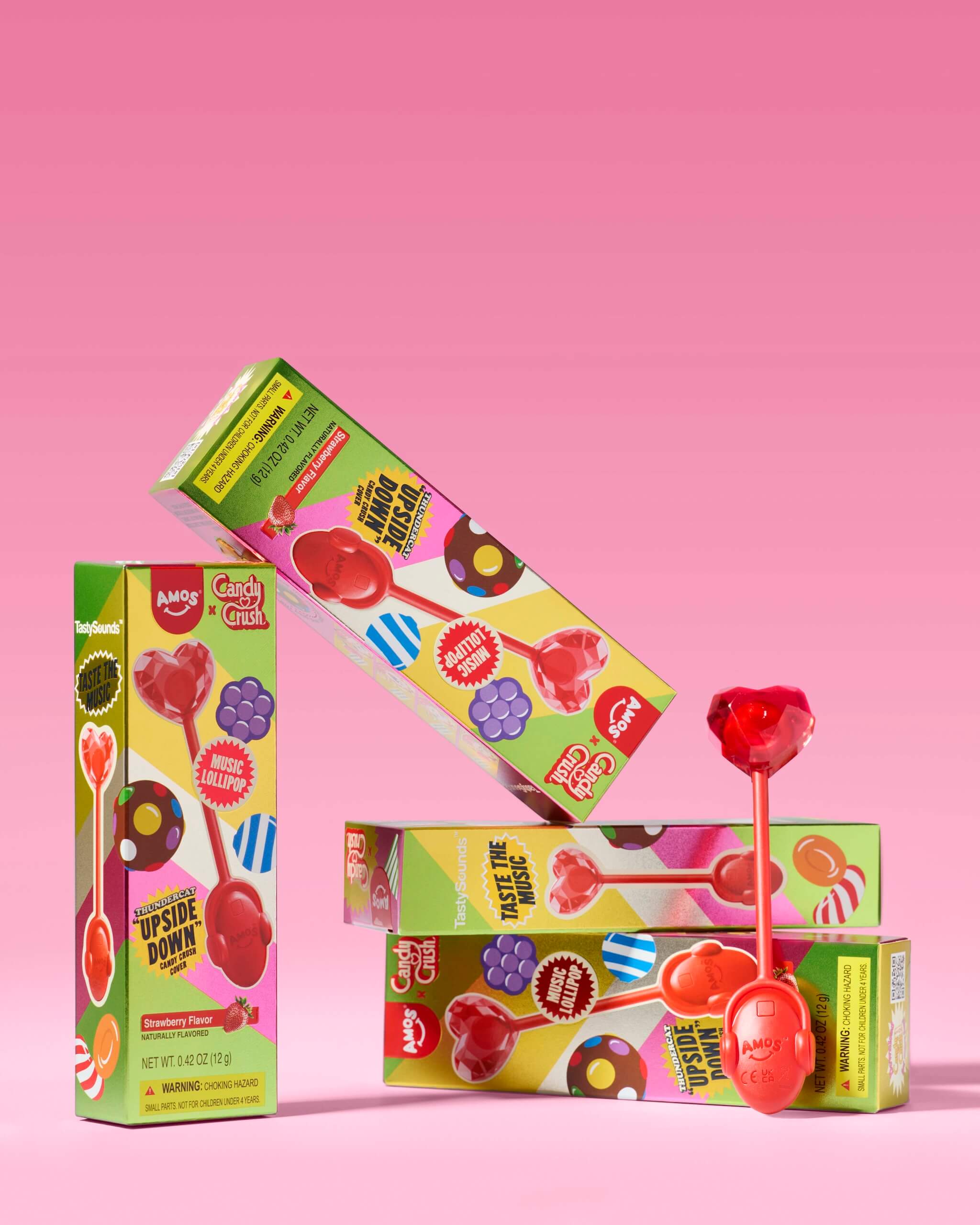 Colorful boxes of lollipops on a pink background