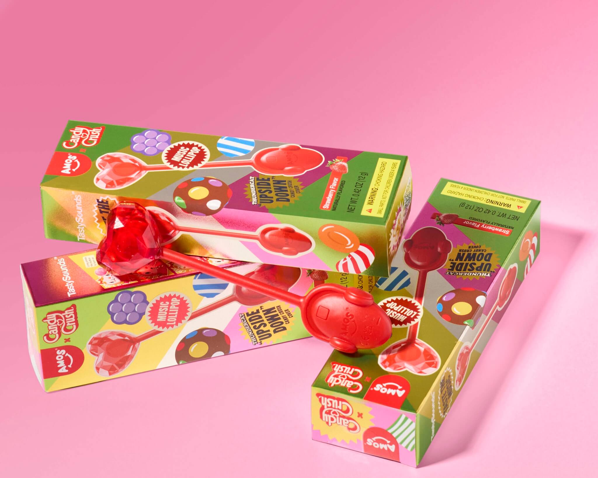 Colorful lollipop boxes with a red lollipop on a pink background